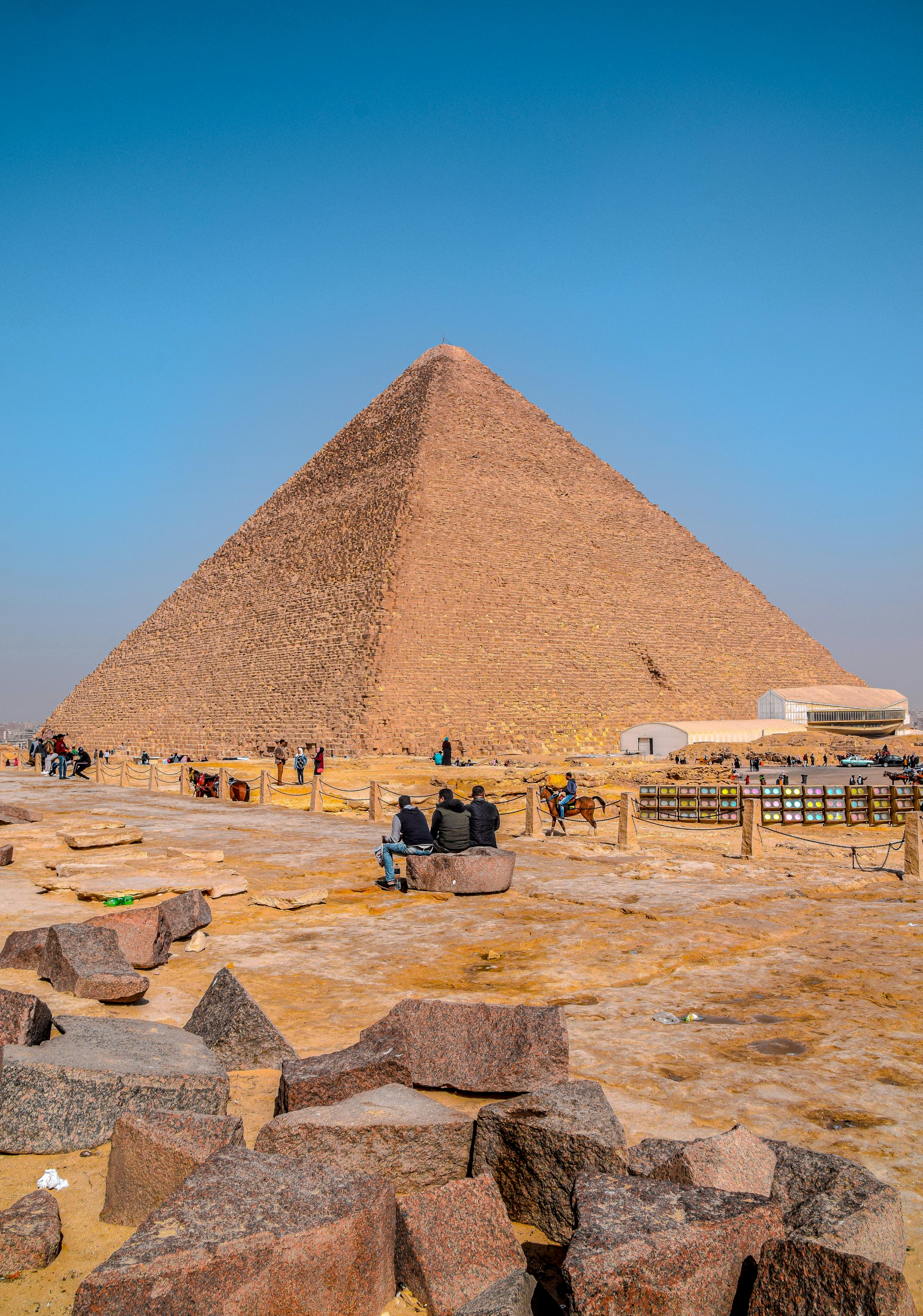 people standing near pyramid under blue sky during daytime